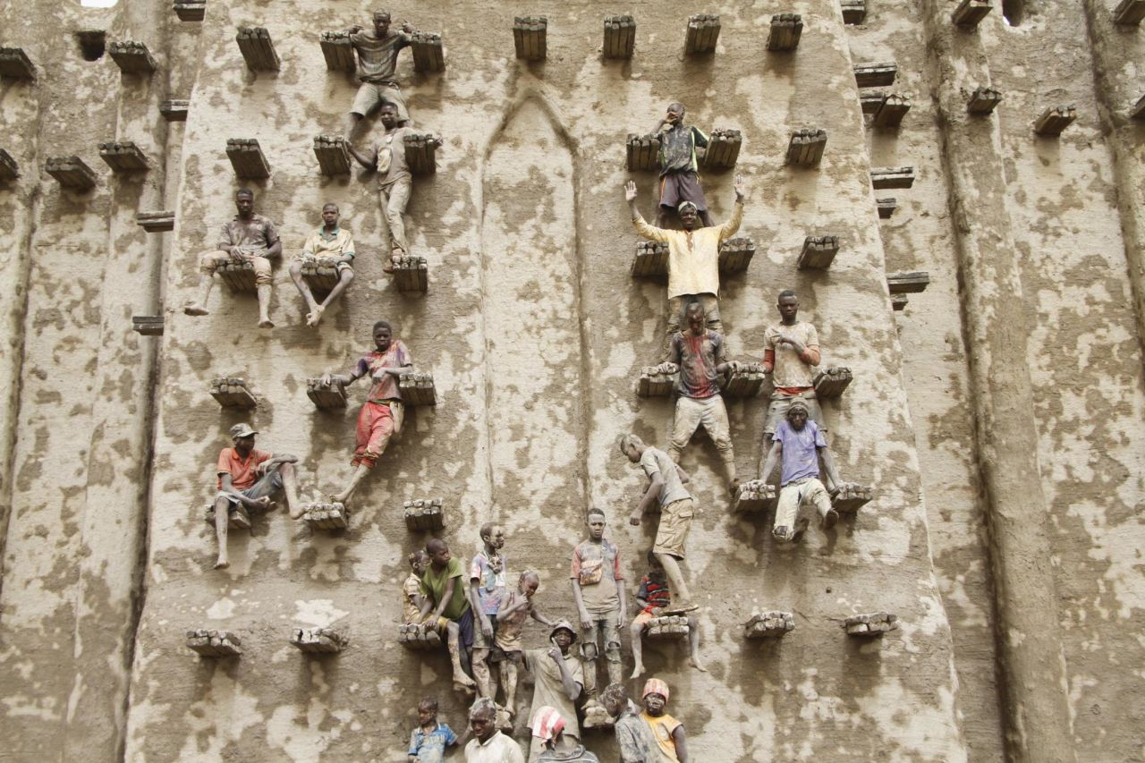 Boys stand on scaffolding during the replastering festival. The Great Mosque is one of a number of buildings in the city designated as World Heritage Sites by UNESCO.