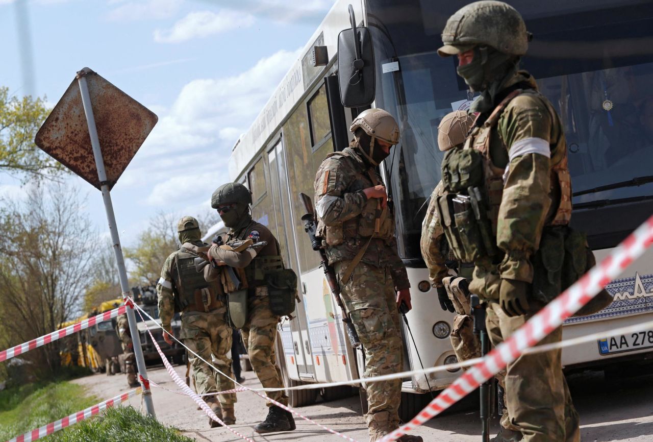 Pro-Russian troops stand guard next to a bus transporting evacuees near a temporary accommodation center in the Ukrainian village of Bezimenne on May 1.  Zelensky says Russia waging war so Putin can stay in power &#8216;until the end of his life&#8217; 220503084852 01 ukraine gallery update