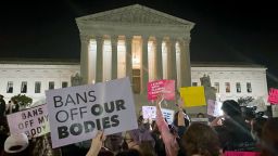 A crowd of people gather outside the Supreme Court, Monday night, May 2, 2022 in Washington.