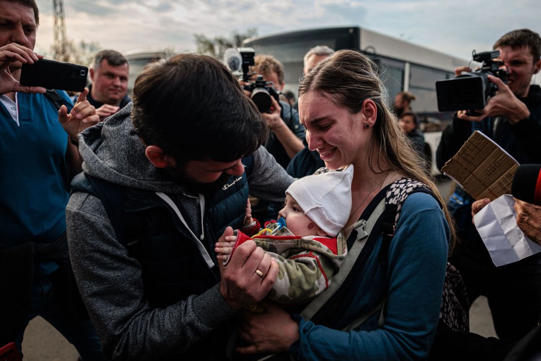 A man welcomes Anna Zaitseva and her 6-month-old son Svyatoslav at a registration and processing area for internally displaced people in Zaporizhzhia.