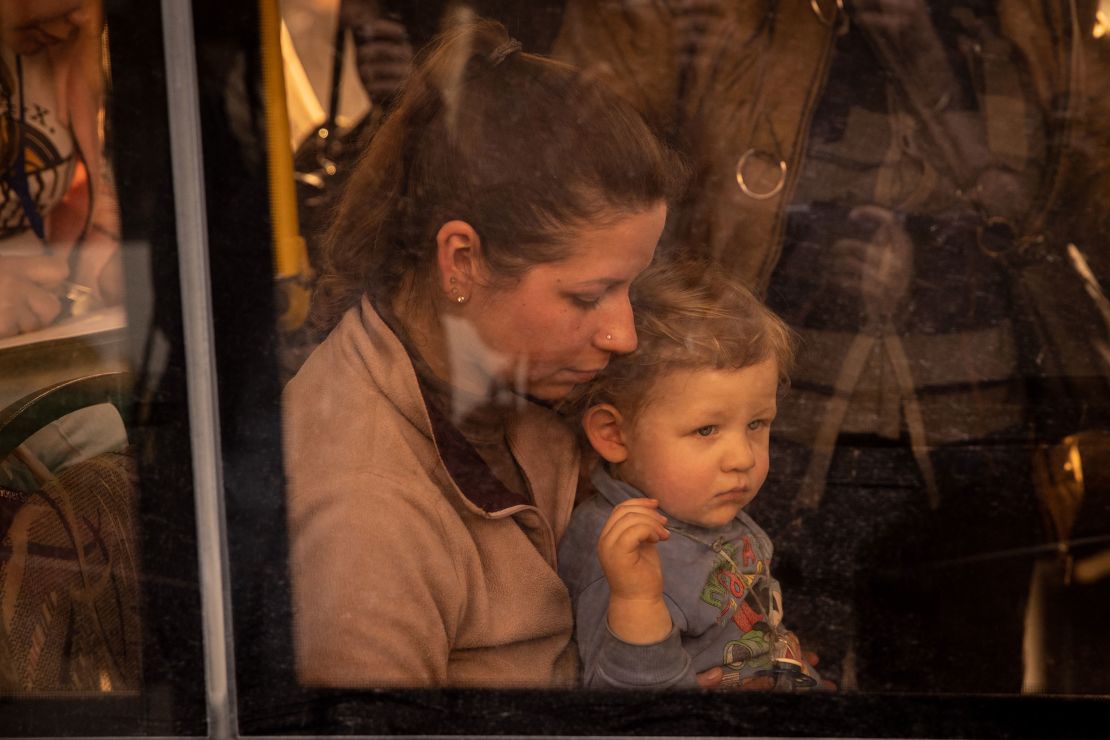 A woman sits with a child on an evacuation bus after fleeing the Azovstal plant in Mariupol.