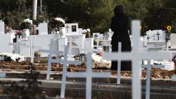 A woman stands next to graves prepared for the victims of the Covid-19 in a cemetery of Thessaloniki on November 11, 2021. - The North of Greece, where inoculation rates are lower than in other regions, has been the worst hit in recent days. (Photo by Sakis MITROLIDIS / AFP) (Photo by SAKIS MITROLIDIS/AFP via Getty Images)