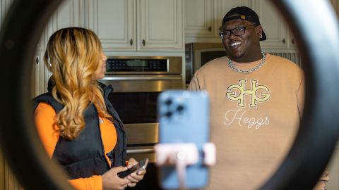 Khamyra Sykes and Robert Dean work on a TikTok video together in the home's kitchen.