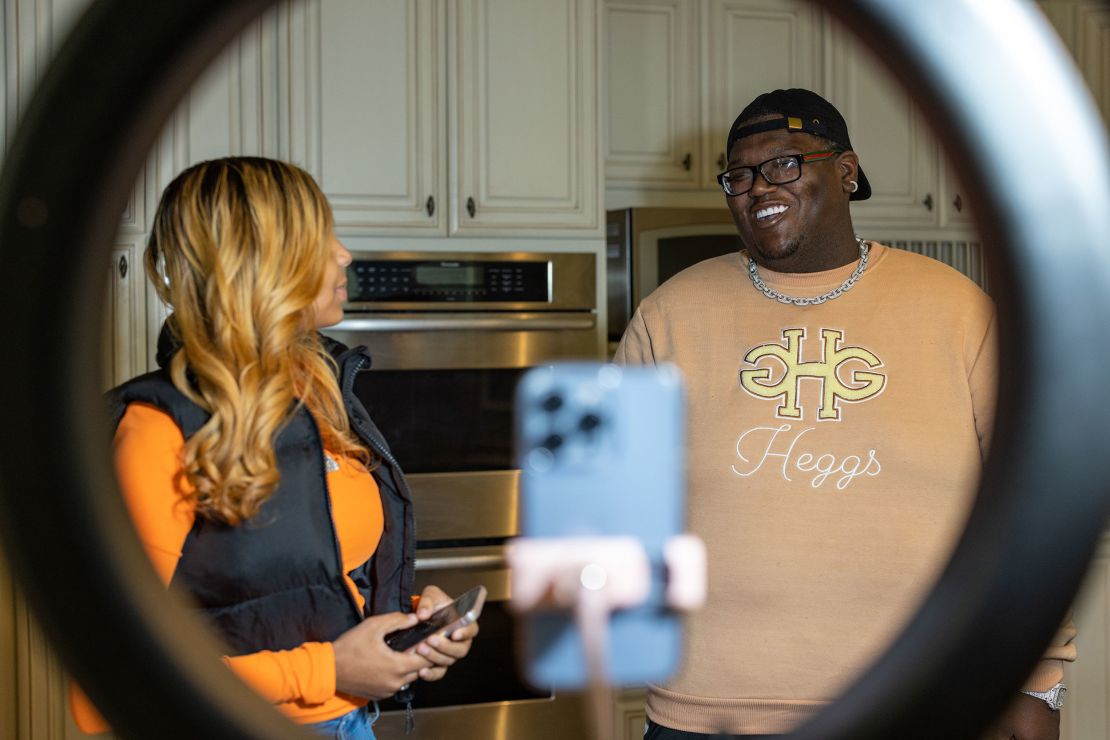 Khamyra Sykes and Robert Dean work on a TikTok video together in the home's kitchen.