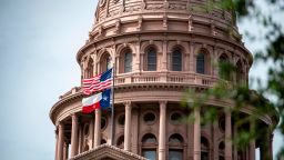 AUSTIN, TX - JULY 12: The U.S. and Texas state flags fly outside the state Capitol building on July 12, 2021 in Austin, Texas. Texas Democrats have fled the state in order to prevent a quorum in protest over a Republican voting protection bill that they say is too restrictive. (Photo by Sergio Flores/Getty Images)