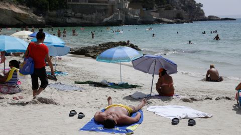 Dermatologists say sunscreen should be reapplied every two hours after spending time outdoors or in water. Beachgoers cool off at Cala Major in Palma de Mallorca, Spain, on August 14, 2021.
