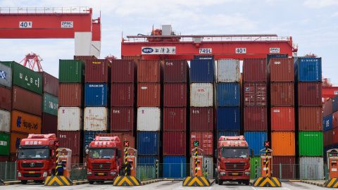 Trucks wait to load containers at Yangshan Deepwater Port on April 27, 2022 in Shanghai, China.