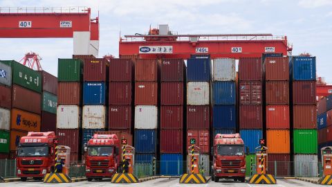 Trucks wait to load containers at Yangshan Deepwater Port on April 27, 2022 in Shanghai, China. 