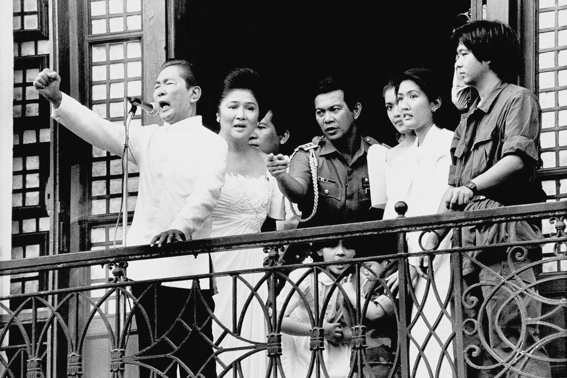 Ferdinand Marcos, with his wife Imelda at his side and Ferdinand Marcos Jr, far right, on the balcony of Malacanang Palace on February 25, 1986 in Manila.