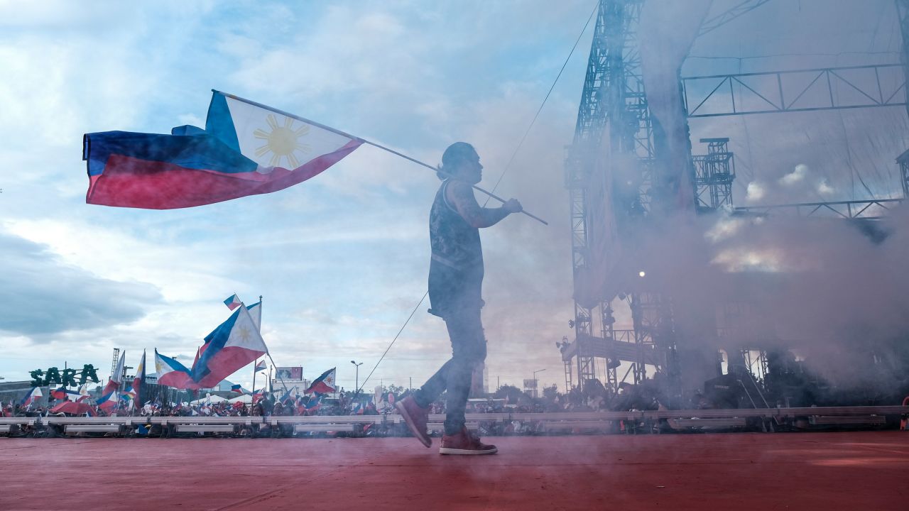 A performer holds the Philippines flag during a campaign sortie in an open parking lot in San Fernando City, Pampanga, on April 29.
