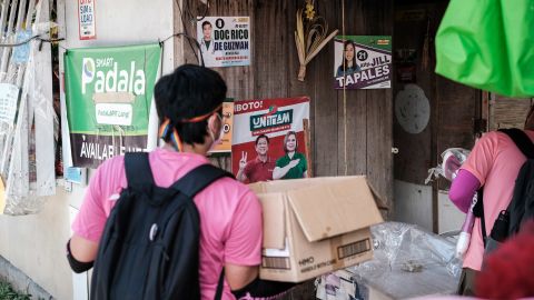 Volunteers carrying paraphernalia conduct a house-to-house campaign for Vice President Leni Robredo's presidential bid in Antipolo City, Philippines, on April 27.