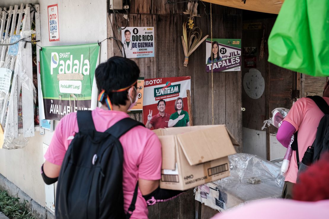 Volunteers carrying paraphernalia conduct a house-to-house campaign for Vice President Leni Robredo's presidential bid in Antipolo City, Philippines, on April 27.
