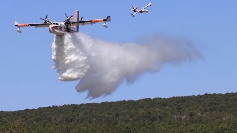 A plane drops water Wednesday to combat the Hermits Peak/Calf Canyon Fire.