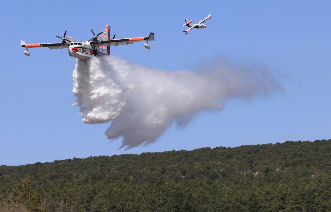A plane drops water Wednesday to combat the Hermits Peak/Calf Canyon Fire.