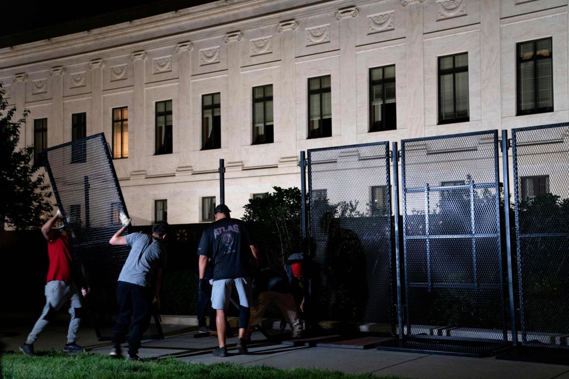 Workers set up unscalable fencing outside the US Supreme Court in Washington, DC, on May 4, 2022.