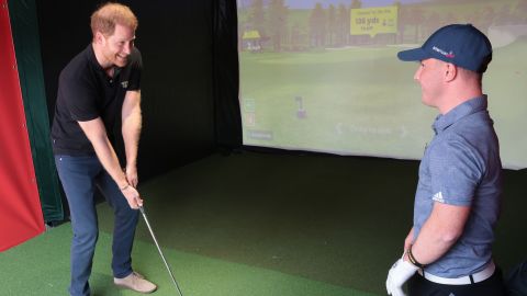 Prince Harry gets a golf lesson from Lawlor.