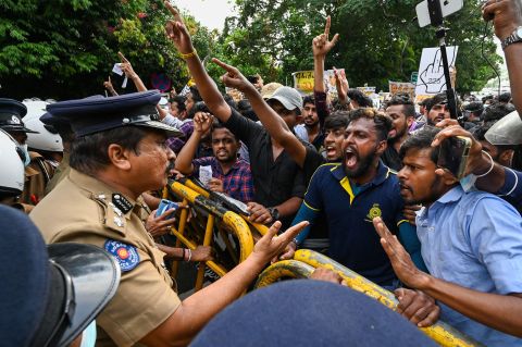 University students speak with a police officer during a demonstration near the parliament building in Colombo, Sri Lanka, on Wednesday, May 4. The island nation of 22 million people is struggling with <a href=