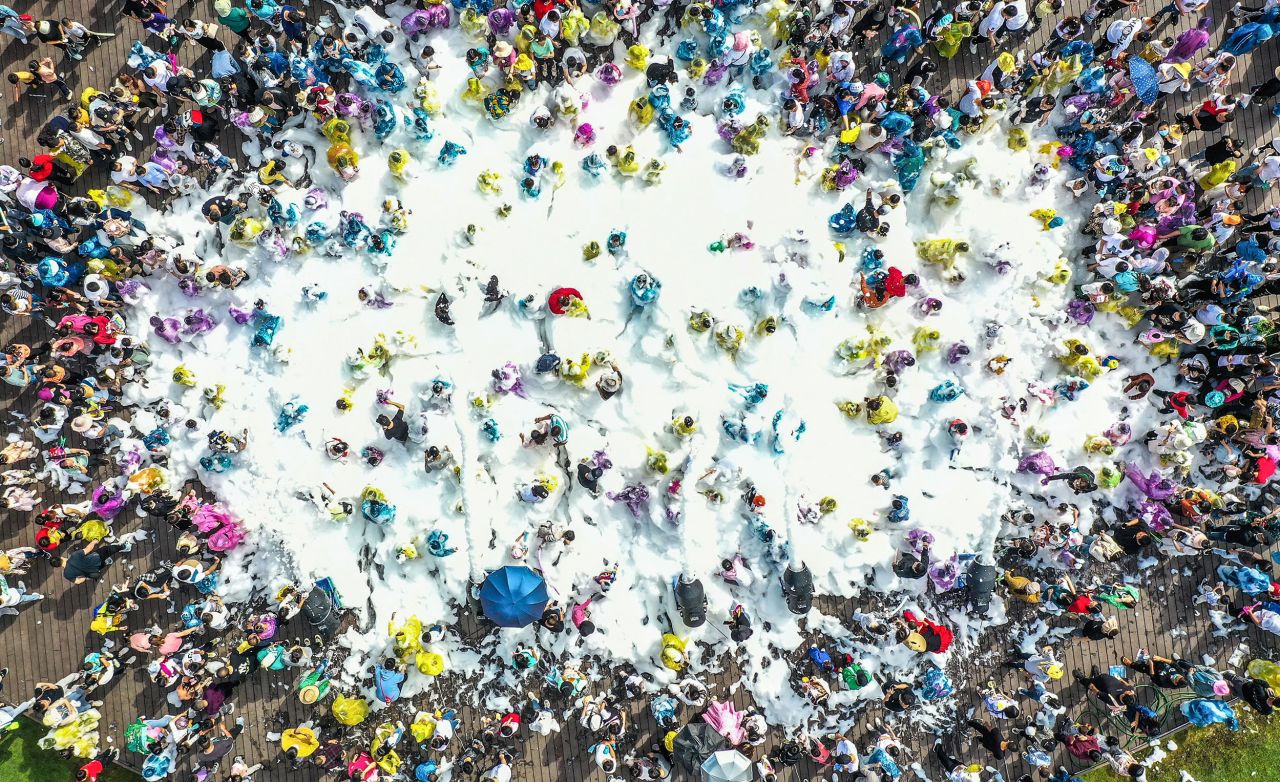 Tourists play with bubbles at a park in Qianxinan, China, on Tuesday, May 3.