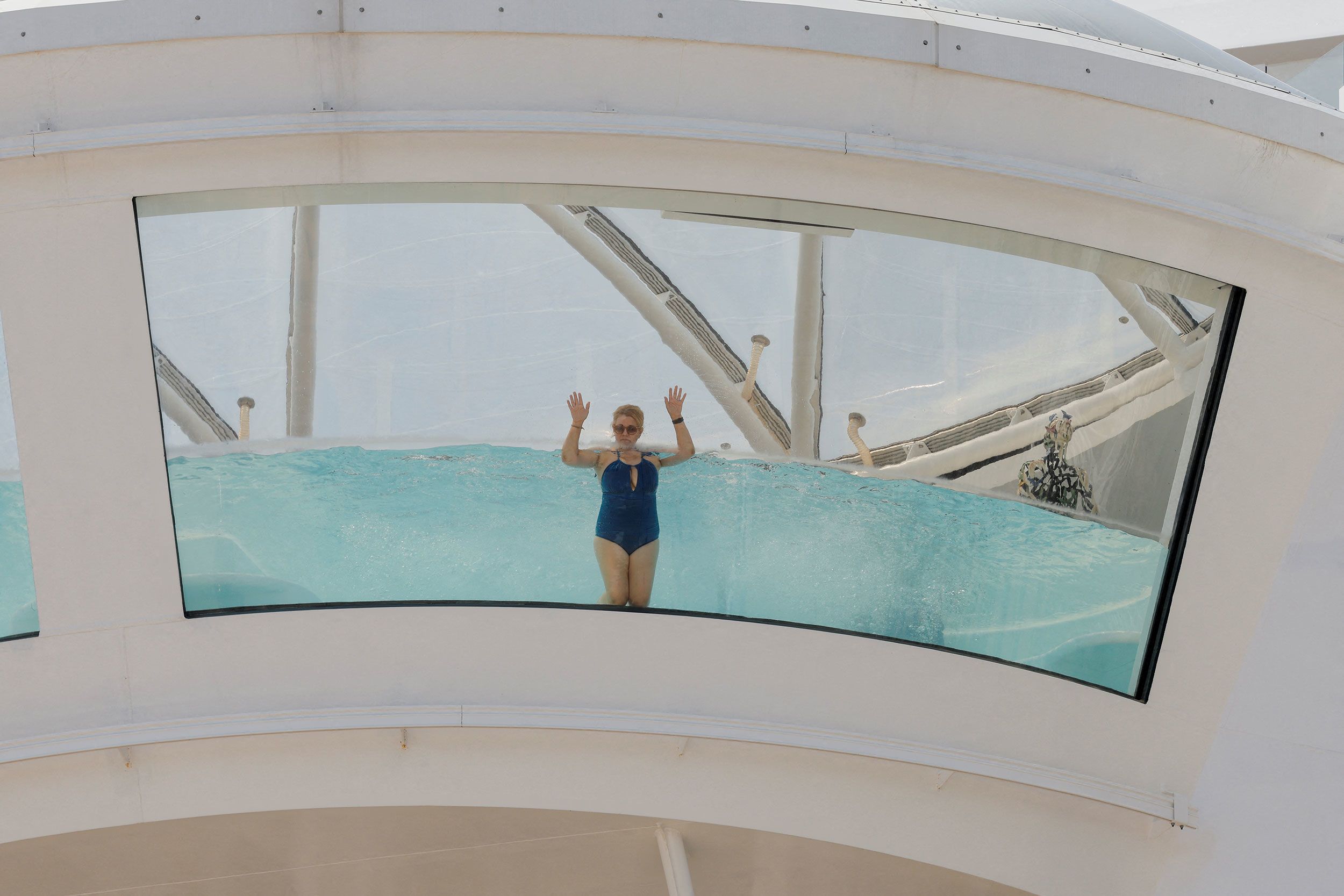 A cruise ship passenger swims in a pool.