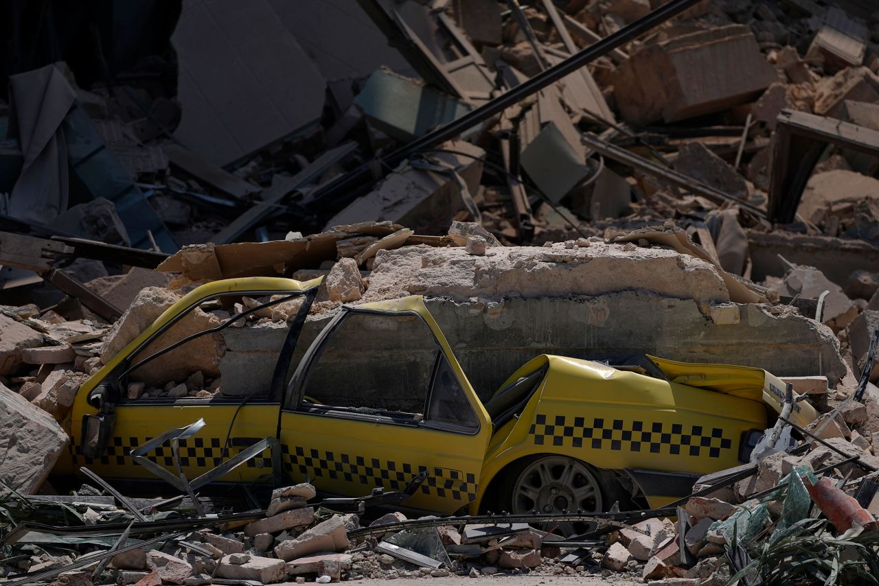 A taxi is buried in the rubble.
