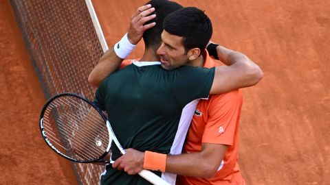 Alcaraz (L) and Djokovic hug at the end of their 2022 ATP Tour Madrid Open semifinal.