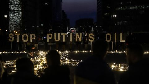 Avaaz members, demonstrators, and Ukrainian activists  stand in front of signs reading "Stop Putin's oil" during a vigil for Ukraine near EU headquarters in Brussels, on March 22.