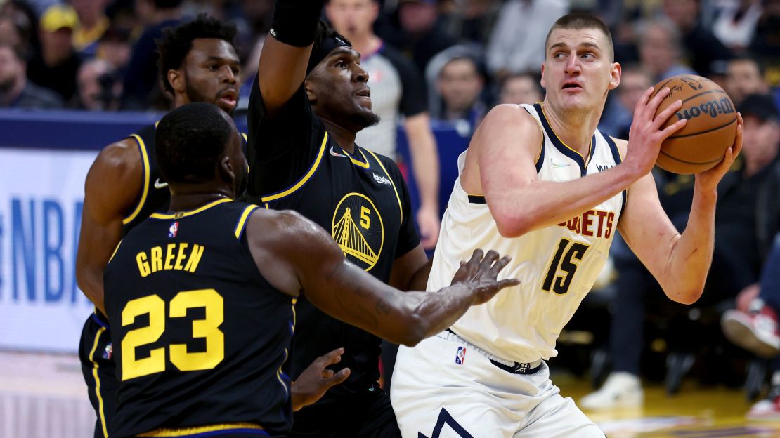 Jokic being defended by the Golden State Warriors' Draymond Green.