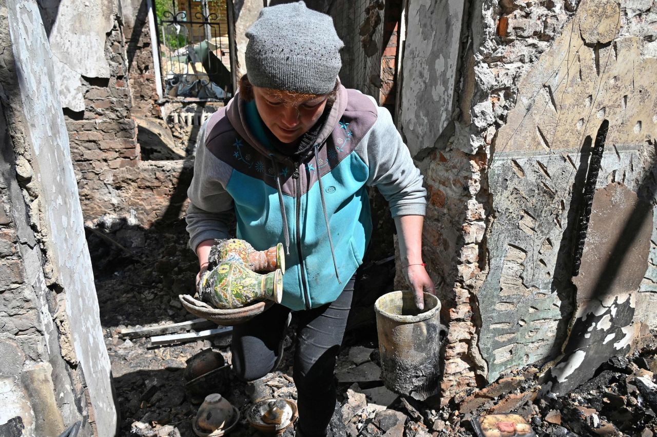 An employee of the museum collects surviving exhibits in the destroyed building of the Hryhoriy Skovoroda National Literary Memorial Museum in the village of Skovorodynivka, in Kharkiv Region, on May 7, 2022.