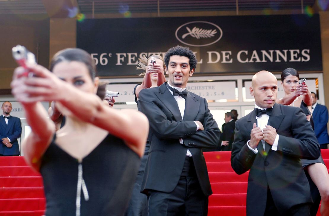 Ramzy Bedia and Eric Judor aka the French comedic duo Eric et Ramzy joke with the Bond girls upon arrival at the Palais des Festivals before the screening of the film "La Petite Lili" by French director Claude Miller during the Cannes film festival in 2003. 