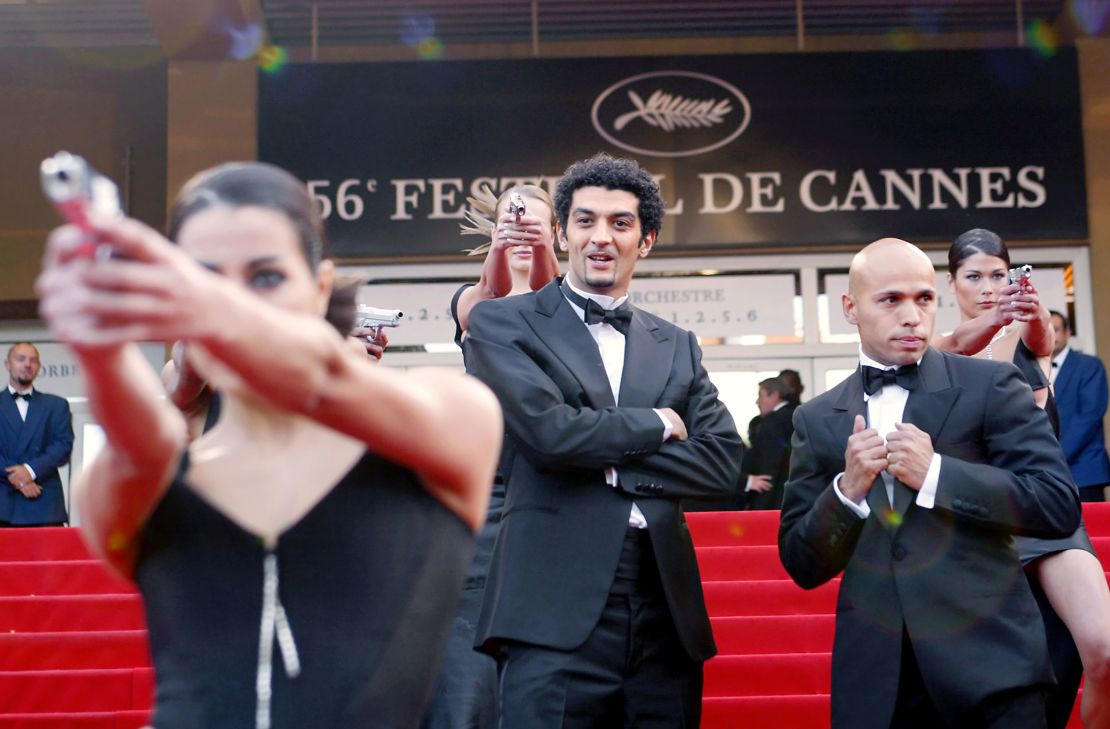 Ramzy Bedia and Eric Judor aka the French comedic duo Eric et Ramzy joke with the Bond girls upon arrival at the Palais des Festivals before the screening of the film "La Petite Lili" by French director Claude Miller during the Cannes film festival in 2003.