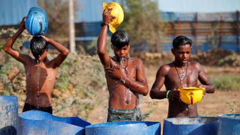 En raison de la vague de chaleur qui fait rage en Inde, les travailleurs versent leurs casques pour se rafraîchir