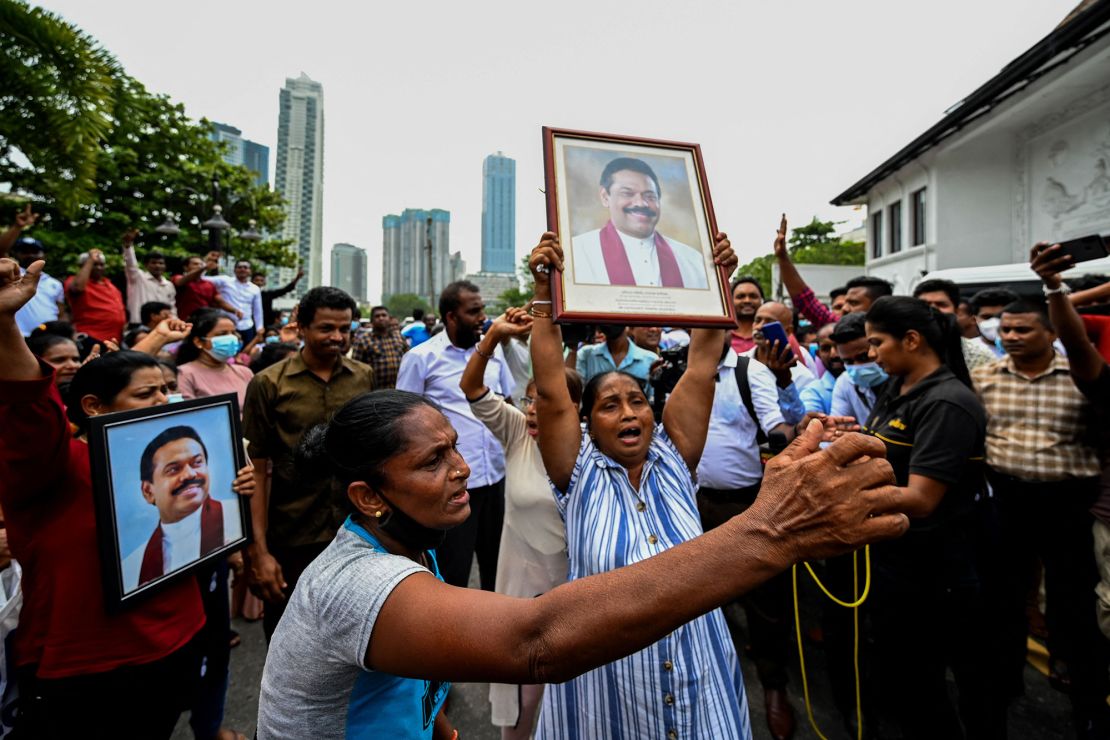 Pro-government supporters hold Prime Minister Rajapaksa's portrait while protesting outside his residence in Colombo.