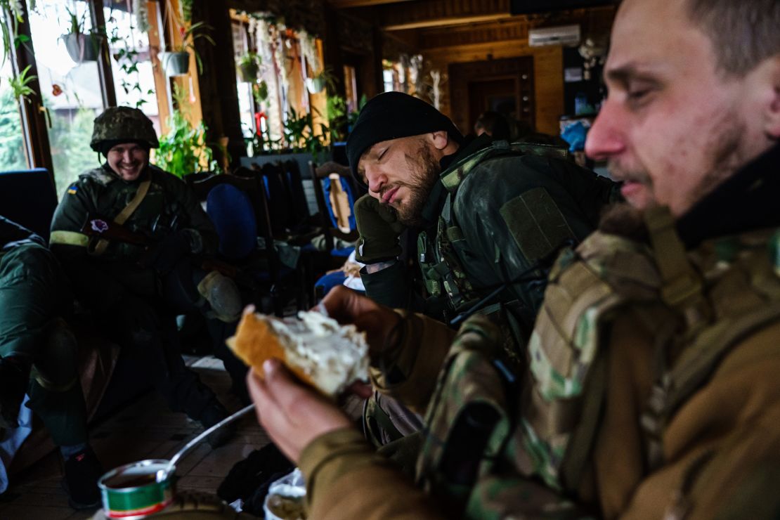 Yaroslav Amosov, resting his head on his hands, with the rest of his fellow Ukrainian soldiers as they prepare to face Russian forces in Irpin, Ukraine.