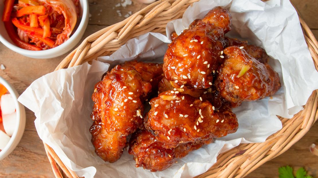 Yum! Korean-style deep-fried chicken wings with garlic sauce and kimchi and pickled radish on the side.