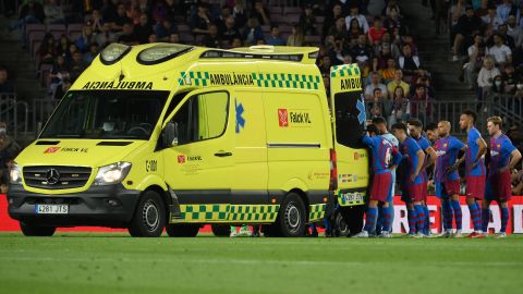 Barcelona's players look on as Ronald Araujo is transported off the field.