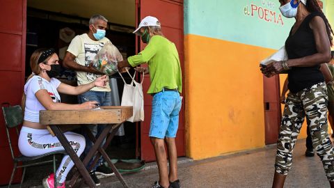 كوبيون يجمعون الطعام المتبرع به في سوبر ماركت في هافانا في أغسطس 2021. 