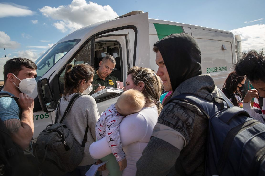 A family from Cuba waits to be transported to a US Border Patrol processing center in December 2021 in Yuma, Arizona.