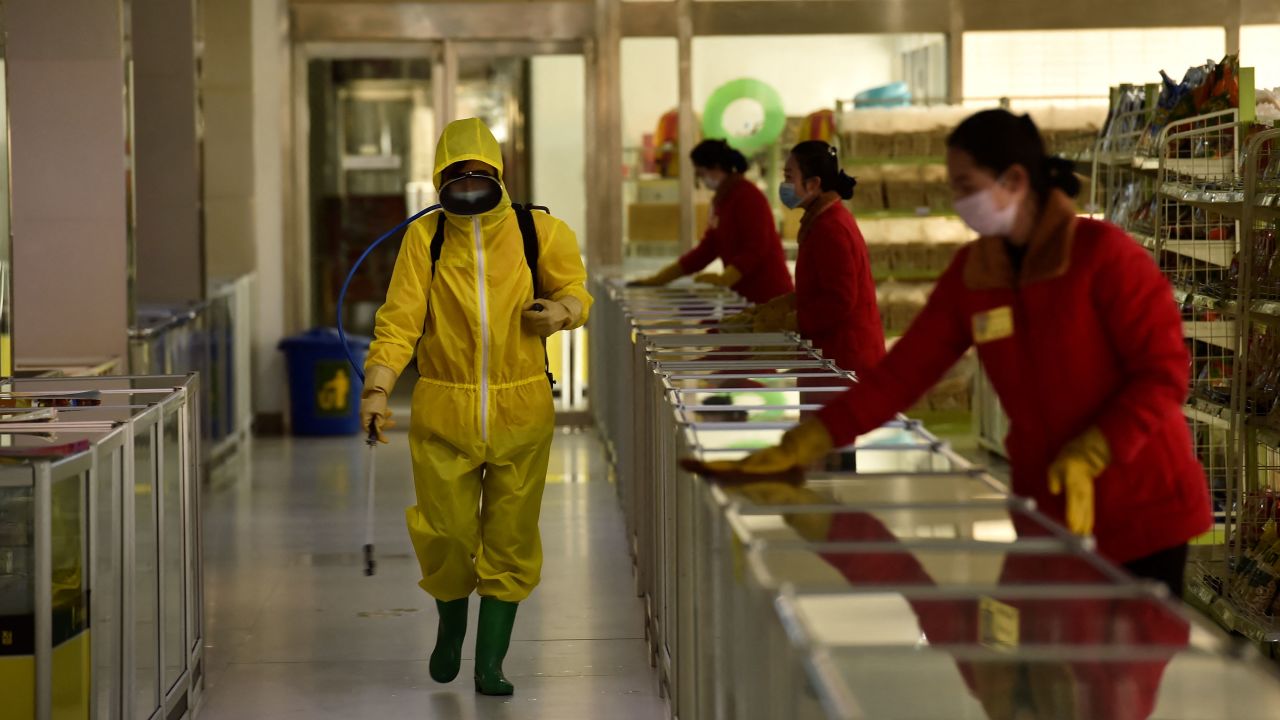 TOPSHOT - Employees spray disinfectant and wipe surfaces as part of preventative measures against the Covid-19 coronavirus at the Pyongyang Children's Department Store in Pyongyang on March 18, 2022. (Photo by KIM Won Jin / AFP) (Photo by KIM WON JIN/AFP via Getty Images)