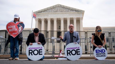 Led by the Rev. Patrick Mahoney, second from right,, a small group of anti-abortion activists prays in front of the Supreme Court building on Wednesday, May 11, 2022, in Washington.