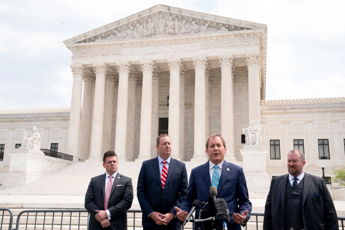 Texas Attorney General Ken Paxton (2R) and Missouri Attorney General Eric Schmitt (2L) speak to reporters in front of the US Supreme Court in Washington, DC, on April 26, 2022. 