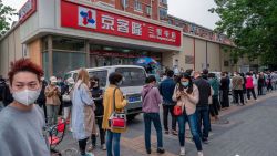 BEIJING, CHINA - MAY 12: People line up outside a supermarket to buy food after a rumour of an impending COVID-19 lockdown that was denied by officials was posted to social media on May 12, 2022 in Beijing, China. China is trying to contain a spike in coronavirus cases in the capital Beijing after hundreds of people tested positive for the virus in recent weeks, causing local authorities to initiate mass testing, mandate proof of a negative PCR test within 48 hours to enter many public spaces, to close schools and retail stores, ban gatherings and inside dining in all restaurants, and to lockdown many neighbourhoods in an effort to maintain the country's zero COVID strategy. (Photo by Kevin Frayer/Getty Images)