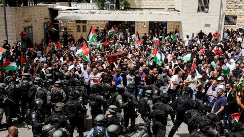 Family and friends carry Abu Akleh's coffin, as Israeli security forces stand guard during his funeral in Jerusalem on May 13.