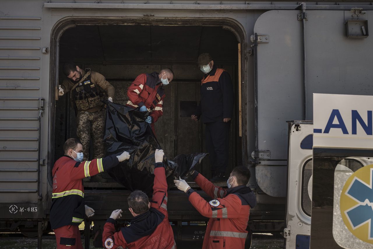 Ukrainian serviceman and emergency workers carry the body of a Russian soldier into a refrigerated train in Kharkiv on May 5. The bodies of more than 40 Russian soldiers were being stored in the refrigerated car.   Zelensky says Russia waging war so Putin can stay in power &#8216;until the end of his life&#8217; 220513083045 01 ukraine gallery update
