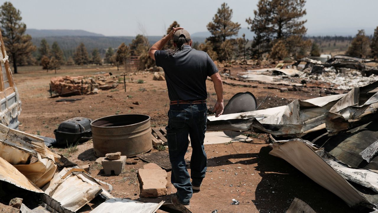 Michael Salazar walks through his property that was burned during the Hermits Peak and Calf Canyon fires in Tierra Monte, New Mexico.