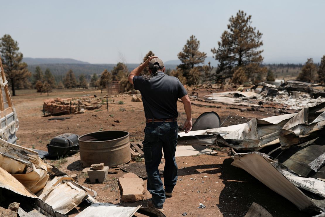 Michael Salazar walks through his property that was burned during the Hermits Peak and Calf Canyon fires in Tierra Monte, New Mexico.