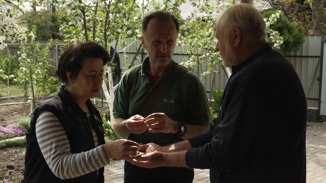 Anzhelika Kolomiec and Ihor Novohatniy show their friend Olegh Bondarenko the metal darts they found scattered around their property.