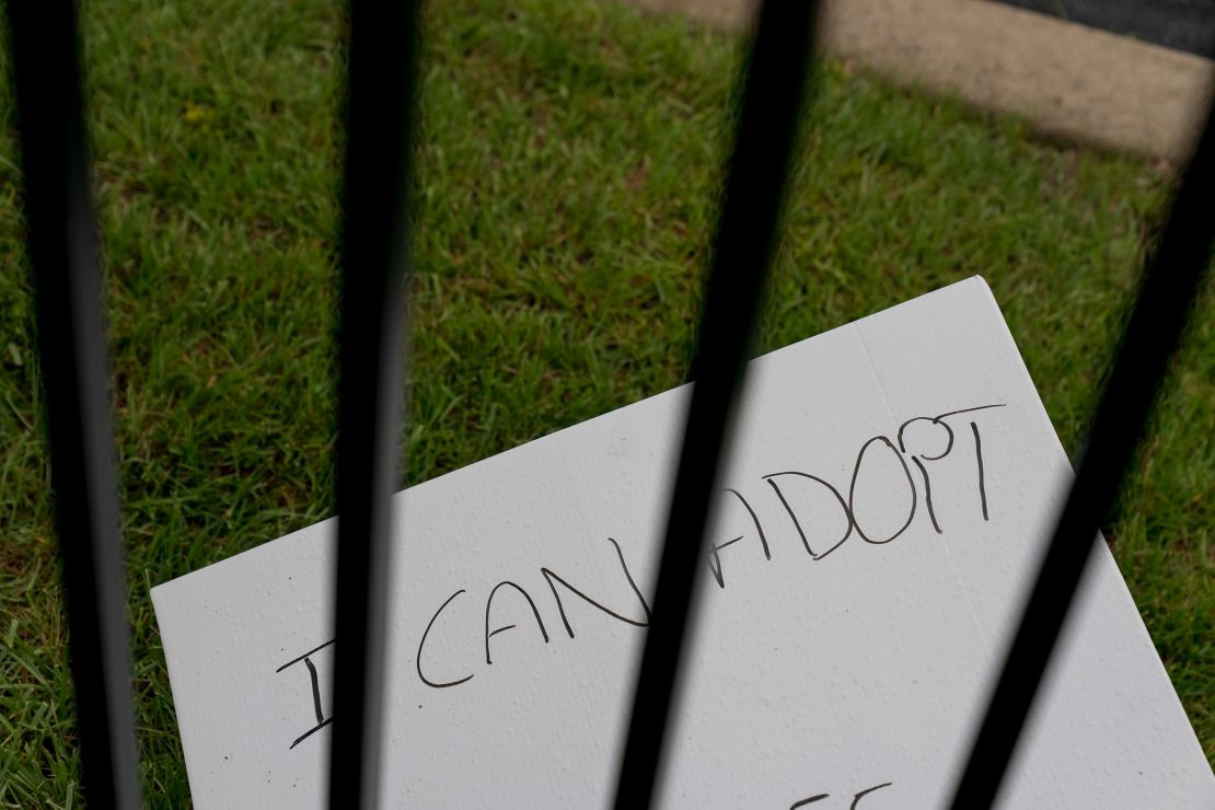A handmade sign lies on the ground outside the fence surrounding the Fairview Heights clinic.