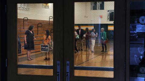 Sabrina Coone-Godfrey, left, speaks with a supporter during a candidate forum at West Forsyth High School.