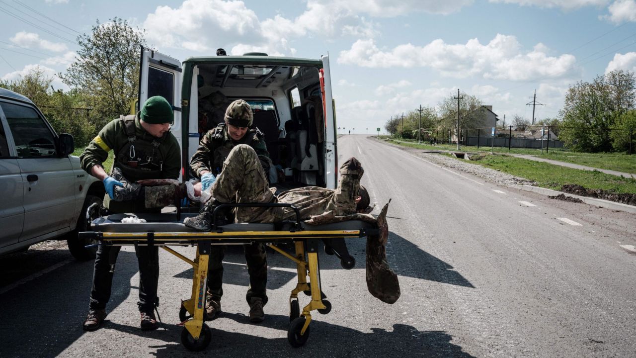 Members of the Ukrainian Army's mobile evacuation unit treat a soldier wounded on the frontline before his transfer to a hospital by ambulance, on a road near Lysychansk, eastern Ukraine, on May 10, 2022, amid the Russian invasion of Ukraine. (Photo by Yasuyoshi CHIBA / AFP) (Photo by YASUYOSHI CHIBA/AFP via Getty Images)