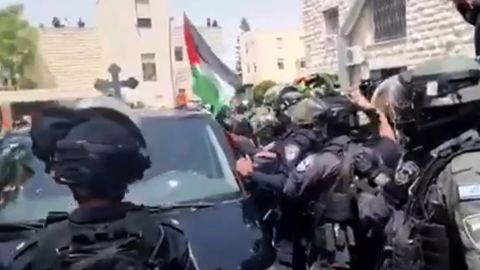 Israeli forces removed Palestinian flags from a hearse carrying the coffin of Shireen Abu Akleh as it moved through the streets of Jerusalem Friday.